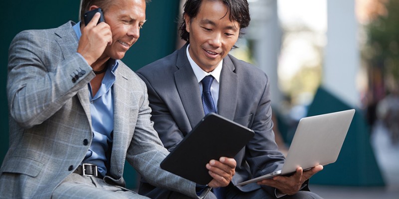 Businessmen using electronic gadgets